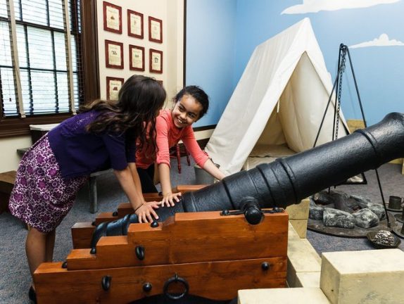Two children investigating a canon at the Military Museum.