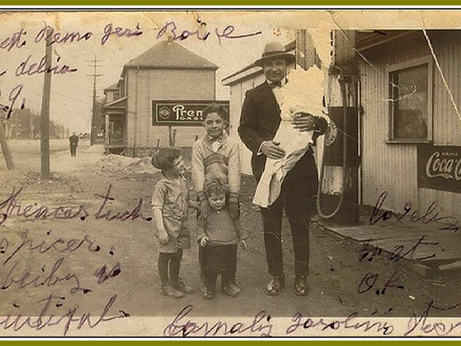 A man with several children in front of a gas pump 1929.