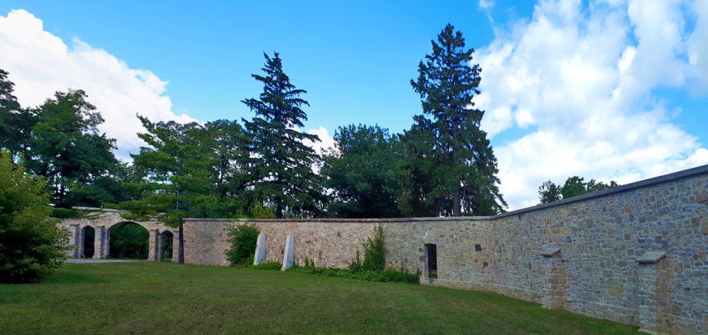 Expansive view of a tall and buttressed mortared Limestone wall.
