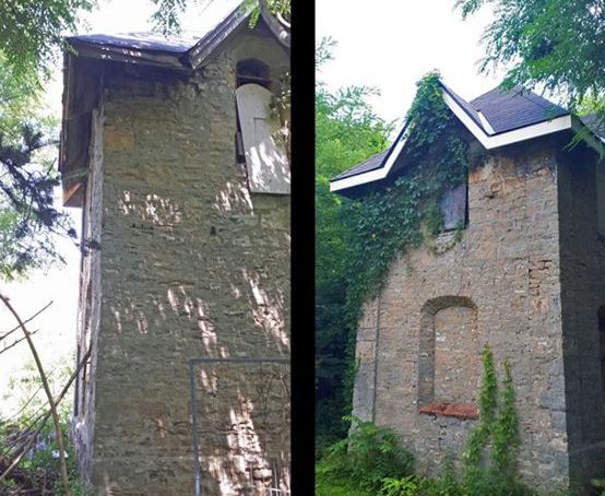 Detail of a tall stone structure with boarded windows and modern shingle roof that once served as a Dovecoat.