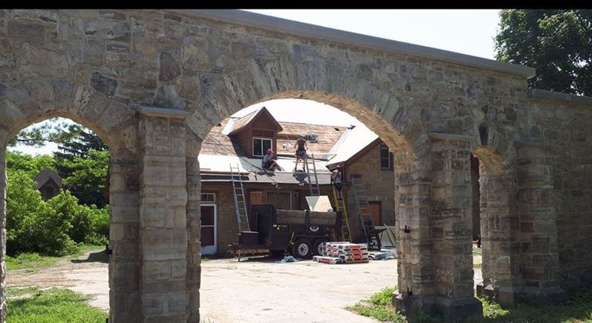 Detail of a tall mortared Limestone wall with arches and buttresses.