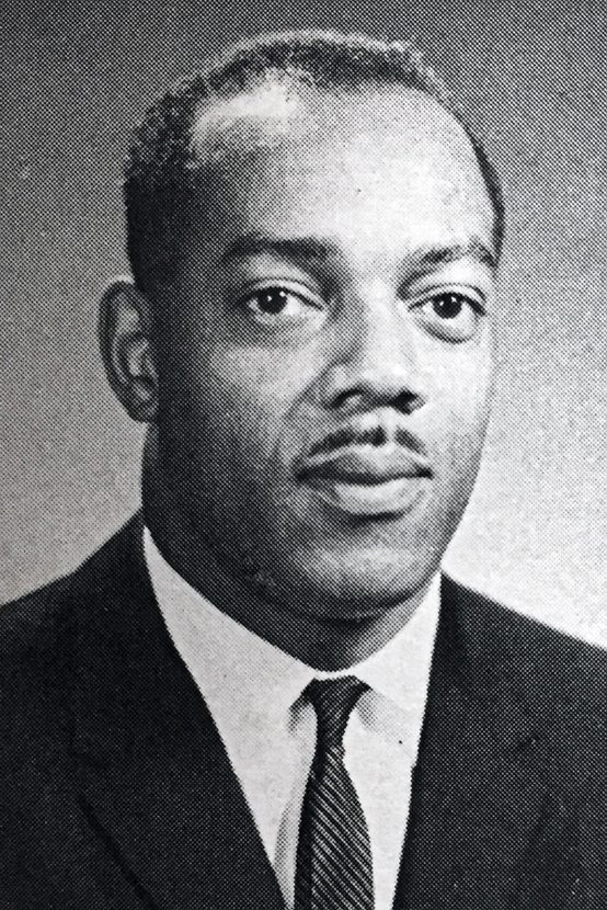 Head shot of a man with moustache wearing a suit and tie.