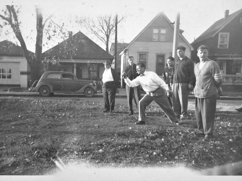 Men playing Bocce amid houses with Stelco Mill 12-10 in the background.