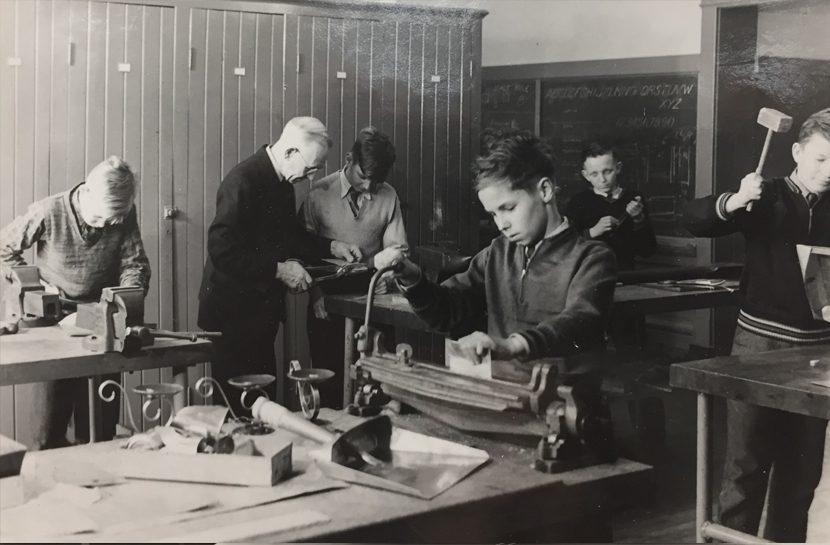 Teacher and male students in shop class.