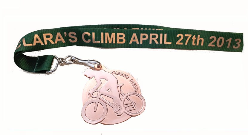Cycling medal on a green lanyard Clara's Climb 2013.