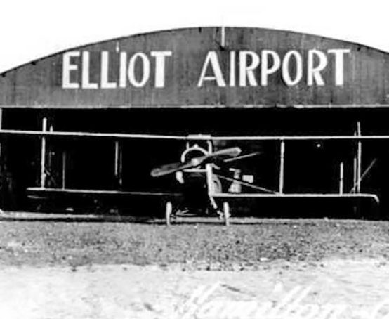 A biplane sits in the entrance of a hangar at the Elliot Airport Hamilton.