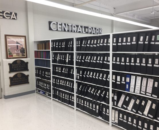 Shelves of Board of Ed. minute books at the Educational Archives.