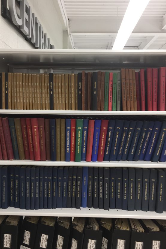Shelves of Board of Ed. minute books at the Educational Archives.