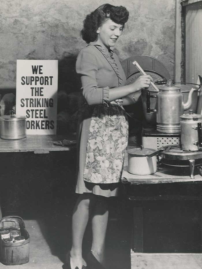 'We Support the Striking Steel Workers' sign near woman cooking food for picketers.
