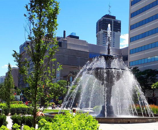 Two tier water fountain in urban park setting.