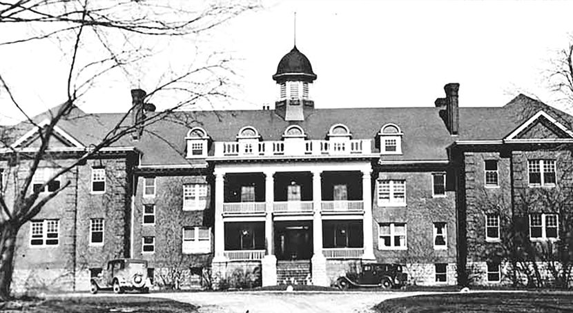 A large imposing multi level Georgian esque structure with gabled roof cupola circa 1932.