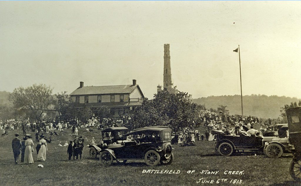 A festive crowd gathered on the Battlefield of Stoney Creek with the Gage House and Monument in the background.