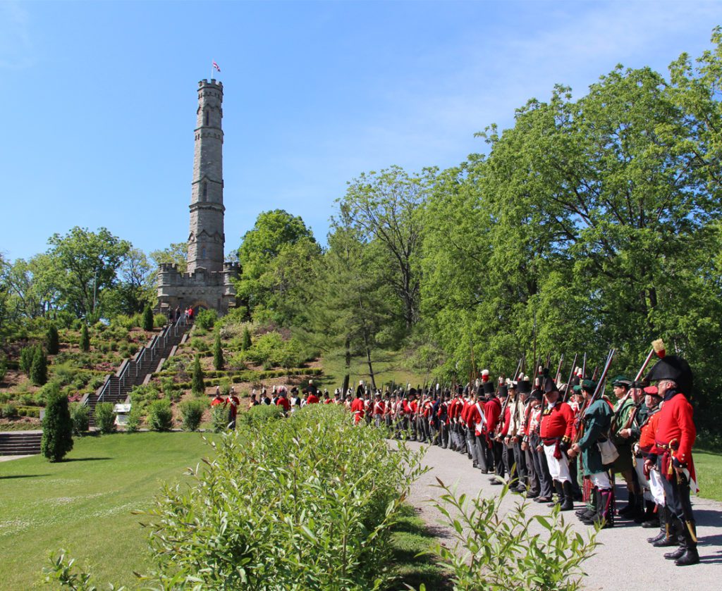 British Soldier reenactors line up outside the Battlefield Monument on a summer day.