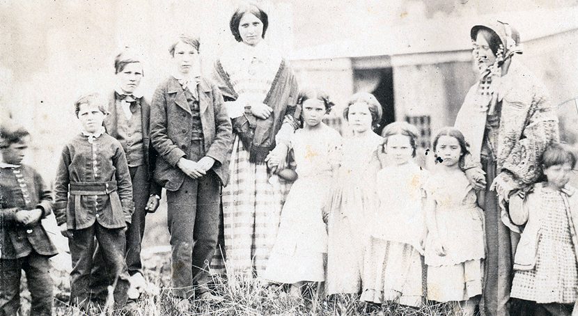 Group photo of two adult women, four young boys and five young girls.