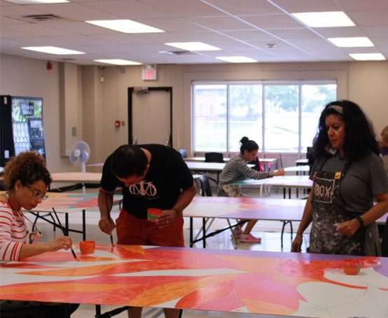 Journey of Hope mural volunteers painting sections.
