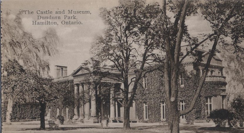 Rear view of Dundurn Castle with ivy covered walls and numerous trees.