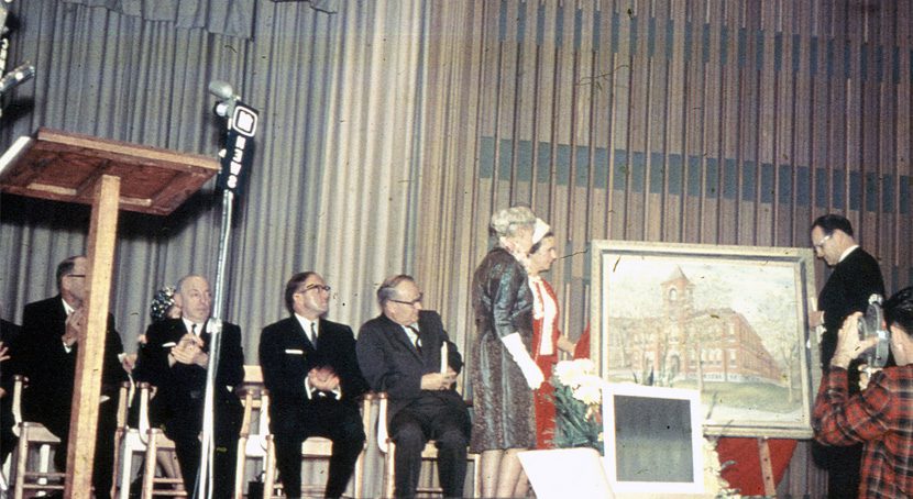 A painting of the original Bennetto building is presented on stage to officials.