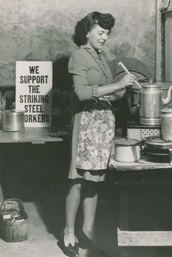 'We Support the Striking Steel Workers' sign near woman cooking food for picketers.