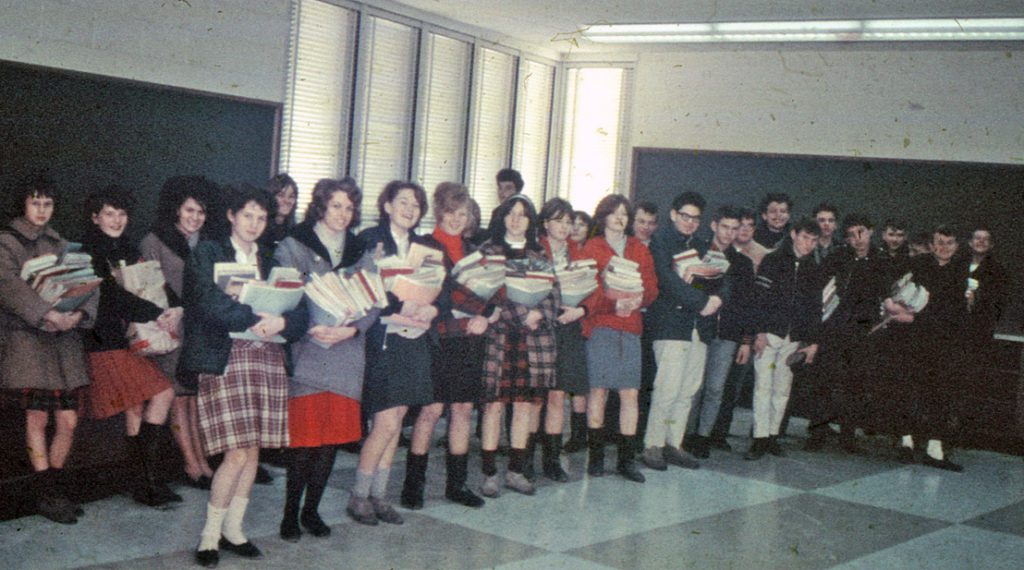 Senior male and female students with arm loads of books inside the new Bennetto building.