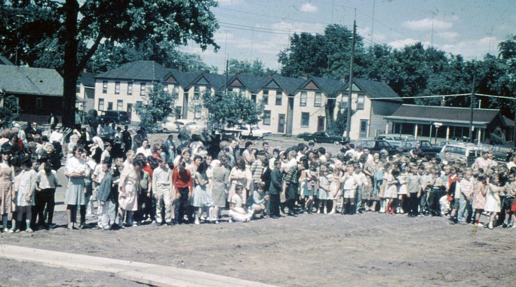 Teachers, students and parents gather outside on a sunny day to attend the Bennetto Sod Turning Ceremony.