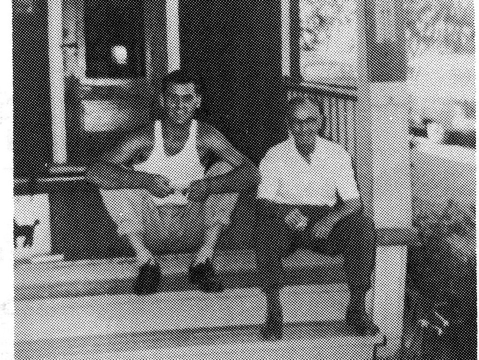 Two men sitting on porch steps.