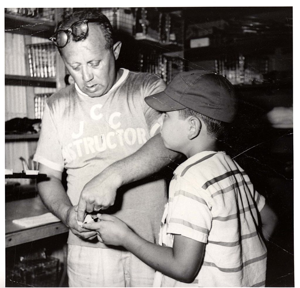 At the Jewish Community Centre, an adult instructor assists a child.