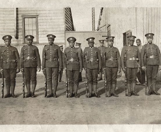 Eight WWI soldiers of the No.2 Construction Battalion standing at attention.