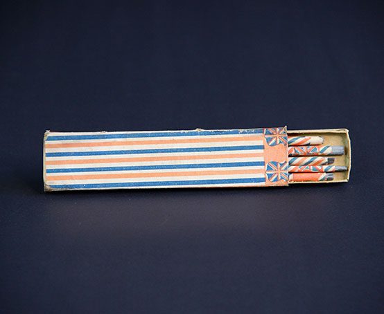 Slate pencils in a cardboard pencil box wrapped in the Union Jack Flag and colours.