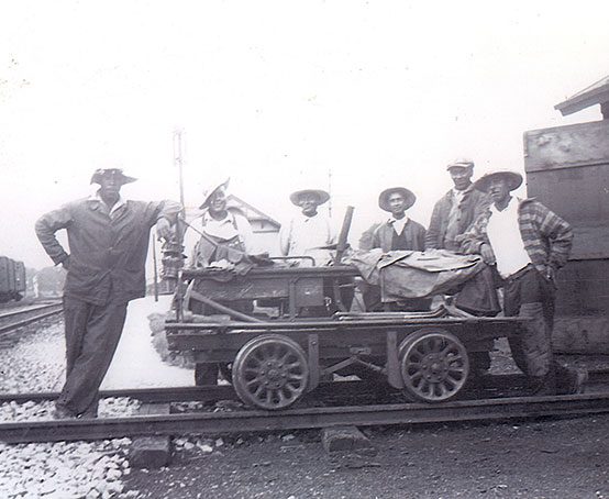 Six railway workers and a handcar.