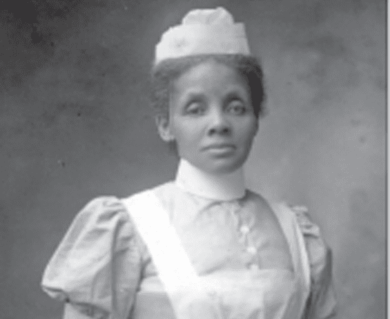 A stoic young woman wearing nurse's uniform.