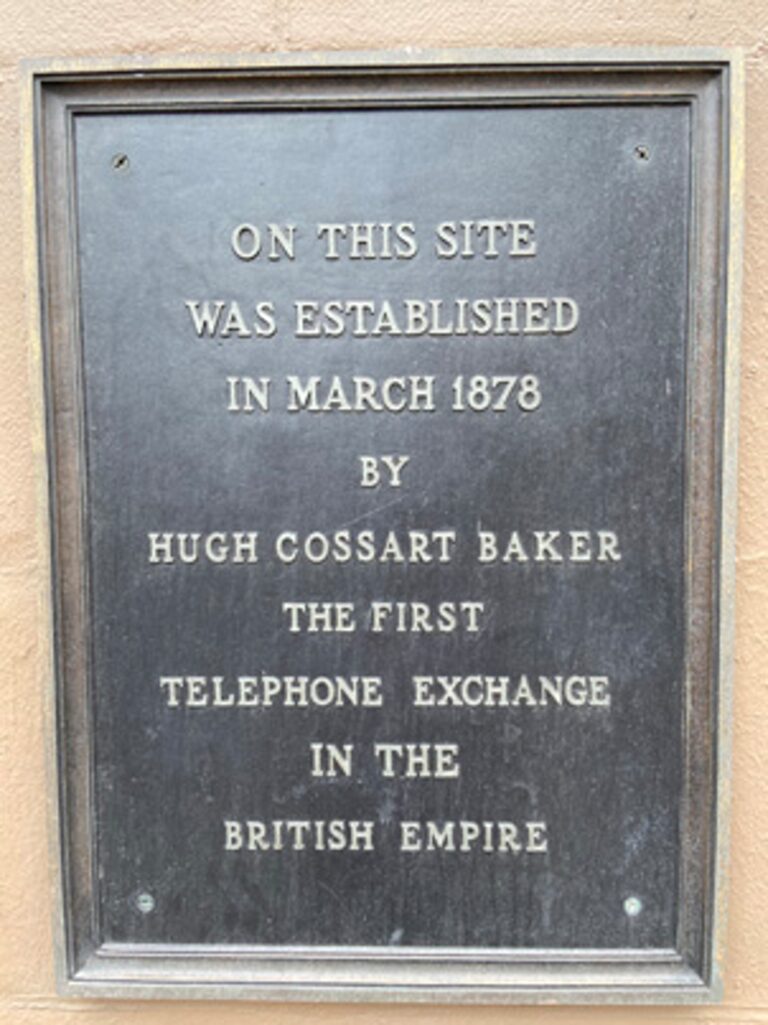 A photo of a plaque. "The text reads: On this site was established in March 1878 by Hugh Cossart Baker the first telephone exchange in the British Empire."