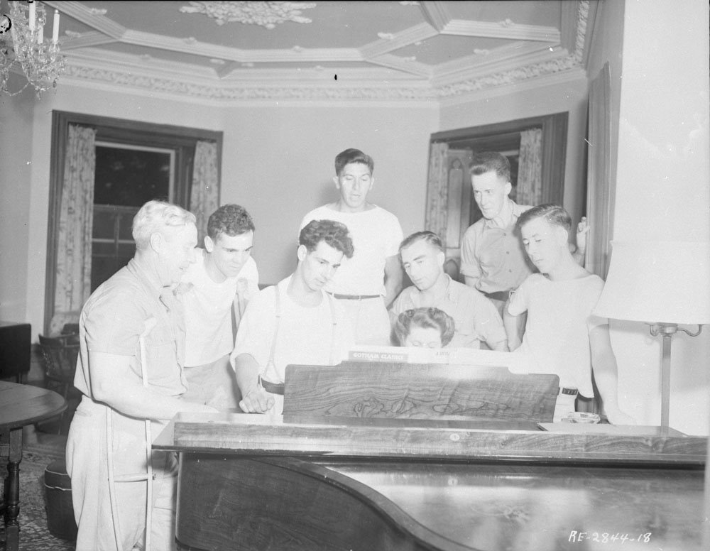 RCAF members gathered around a piano in the ballroom