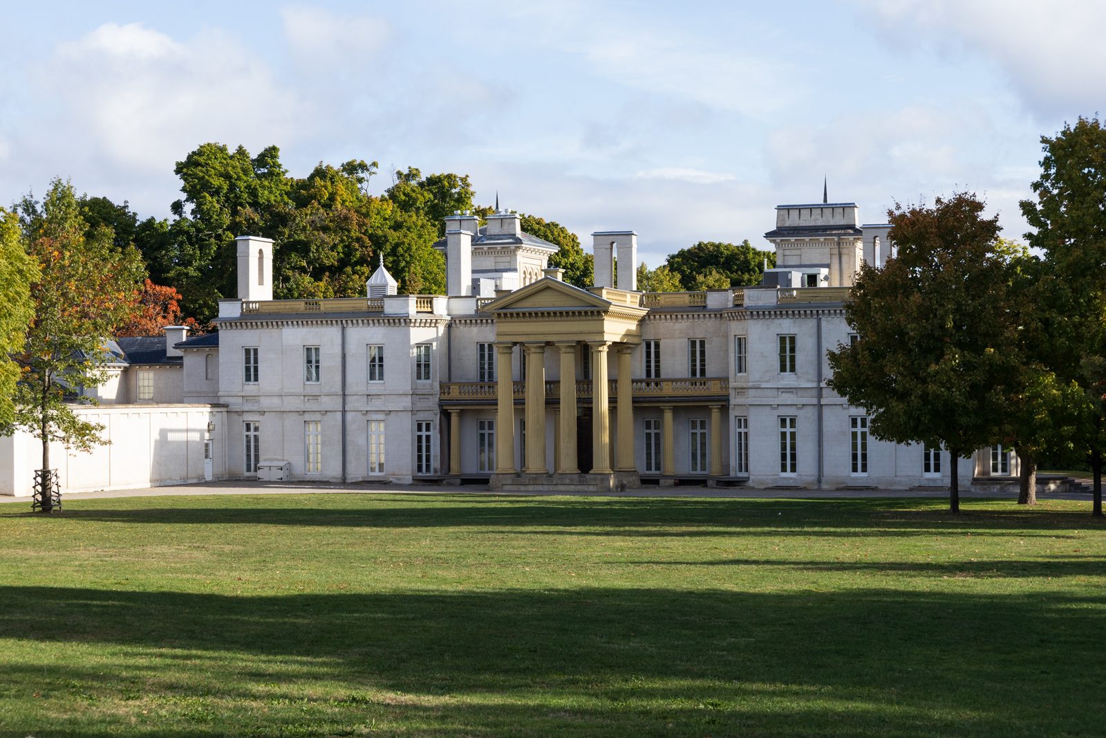 Dundurn Castle seen across its wide front lawn, framed by trees beginning to turn colour.