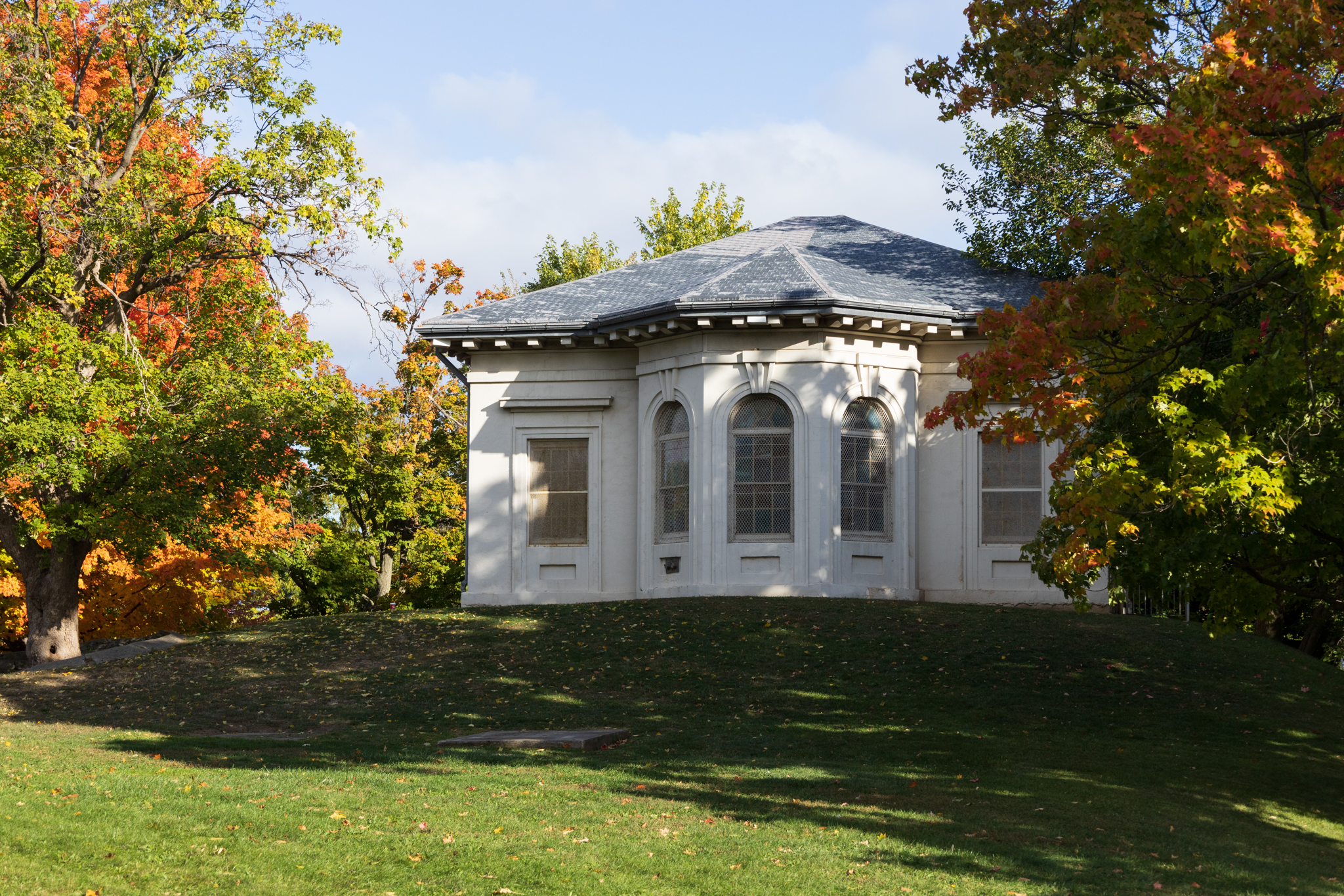 Hamilton Military Museum among the fall trees with vibrant green, orange, and yellow leaves.